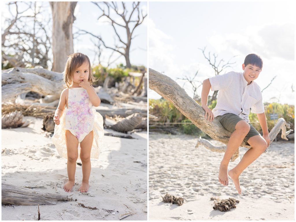 Little girl in white outfit with purple flowers stand in sand on Driftwood Beach during Mommy & Me photo session. Boy in white button down sits on piece of driftwood in Jekyll Island, GA during photo session with Wisp + Willow Photography Co. 