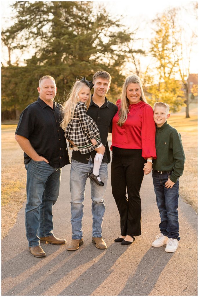 Beautiful family of 5 smiles for camera as they take a new Christmas card picture to update their family portraits.
