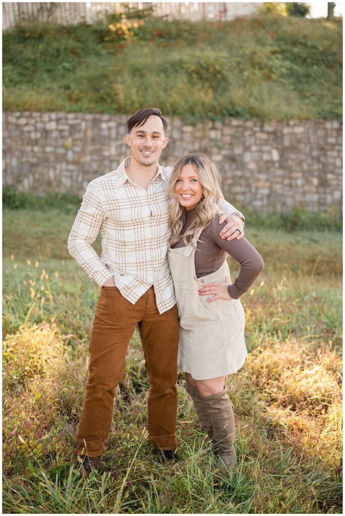 Couple stands in place where they got married at Libby Hill Park in Richmond, VA and smile at camera of Wisp + Willow Photography Co. in the fall.  Check out the blog to see more of this couple and their son!