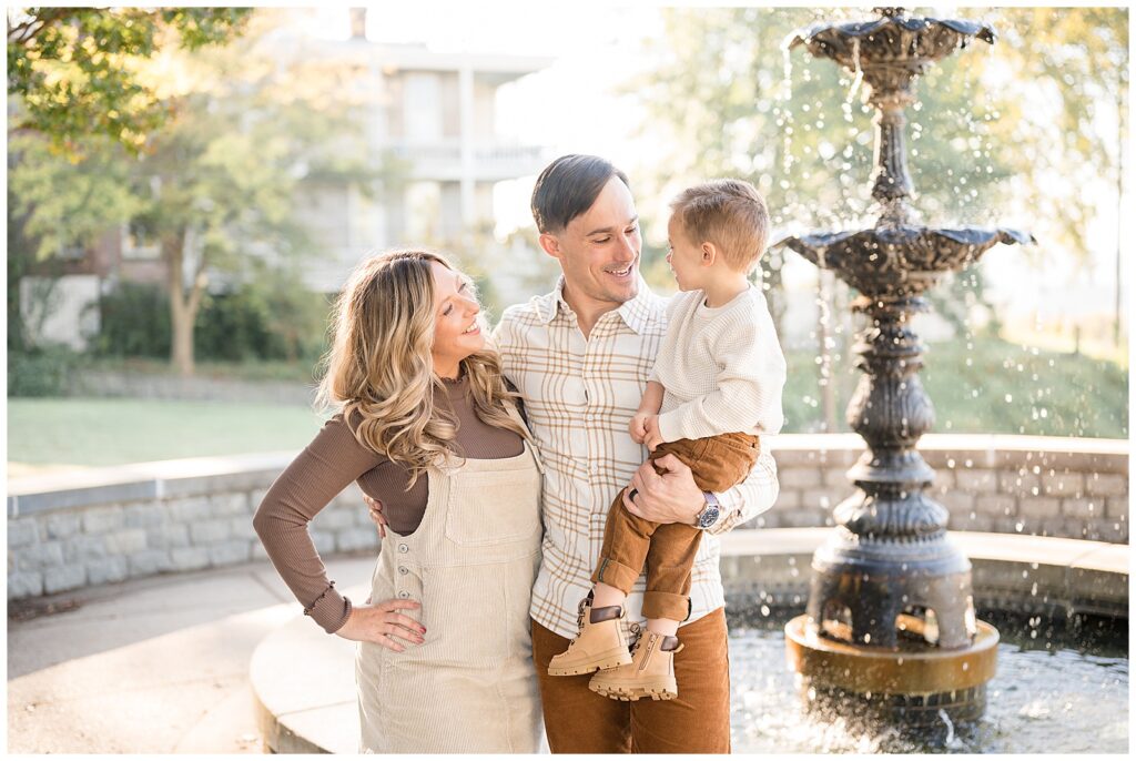 Family of 3 wear coordinating outfits of brown colors and neutrals for their fall family photography session with Richmond, Virginia family photographer, Wisp + Willow Photography Co.