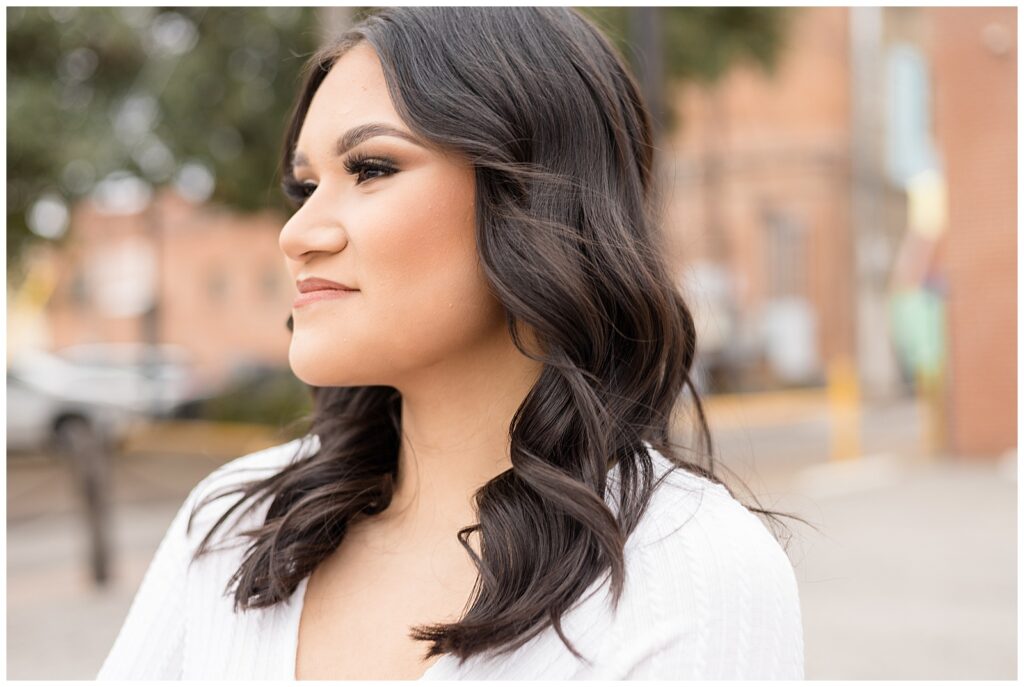Senior portrait session in McKinney, TX has girl look off in the distance with beautiful professional make-up done.