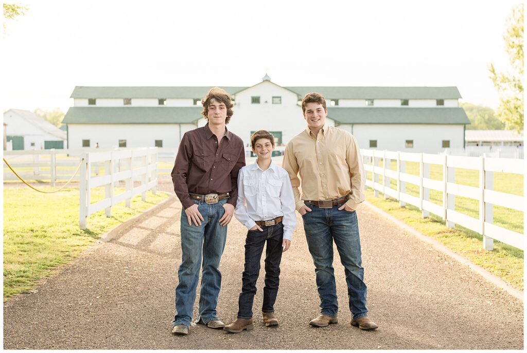 3 young boys stand on gravel driveway in front of barn at Halinsdale Farm in Franklin, TN during their mini-session with Wisp + Willow Photography Co.