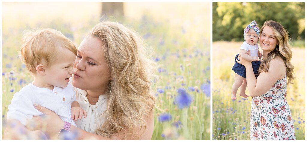 Mom kisses little boy, both wearing white, in wildflower field as he laughs.  Mom holds baby daughter as they both smile at the camera of family photographers Wisp + Willow Photography Co. during their mini session.