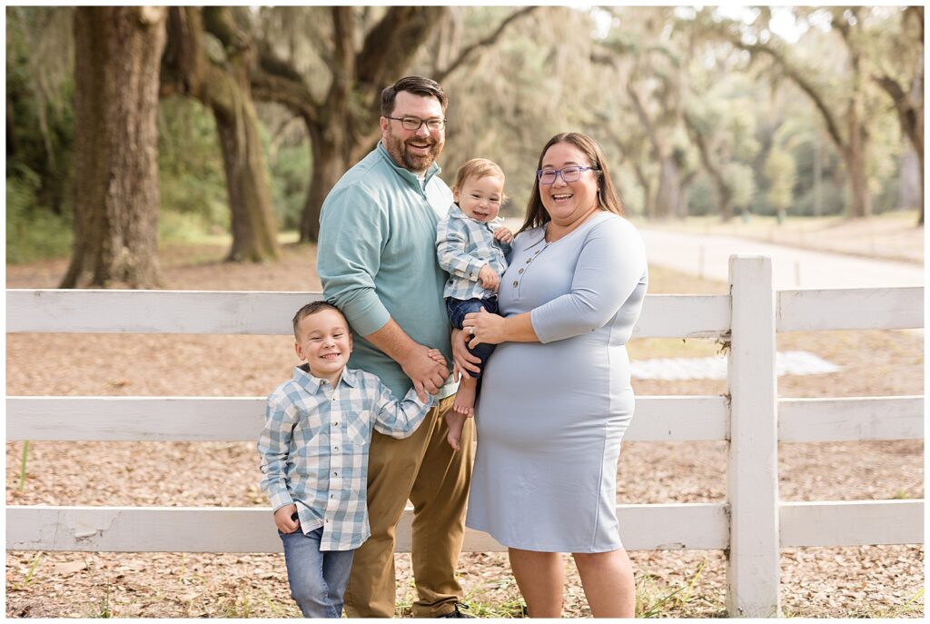 Mom and Dad smile at camera of Wisp + Willow Photography Co. for their family mini session at Wormsloe in Savannah, GA.