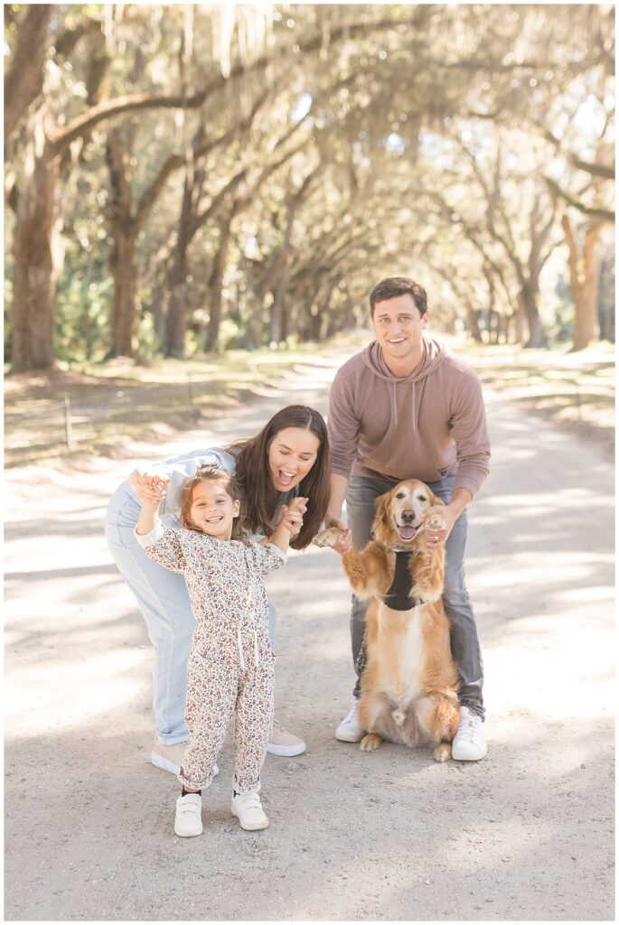 Fun candid family moment with daughter, dog, and parents caught by Savannah family photographer, Wisp + Willow Photography Co. at Wormsloe.