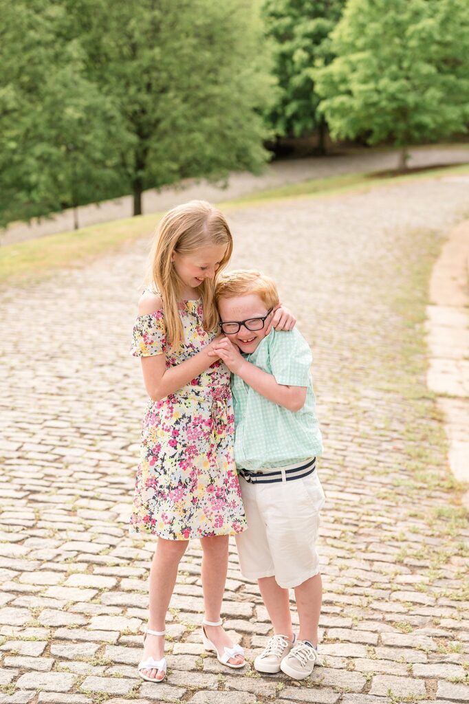 Brother and sister hug each other and make each other laugh as they stand on the cobblestone path of Libby Hill in Richmond, VA.