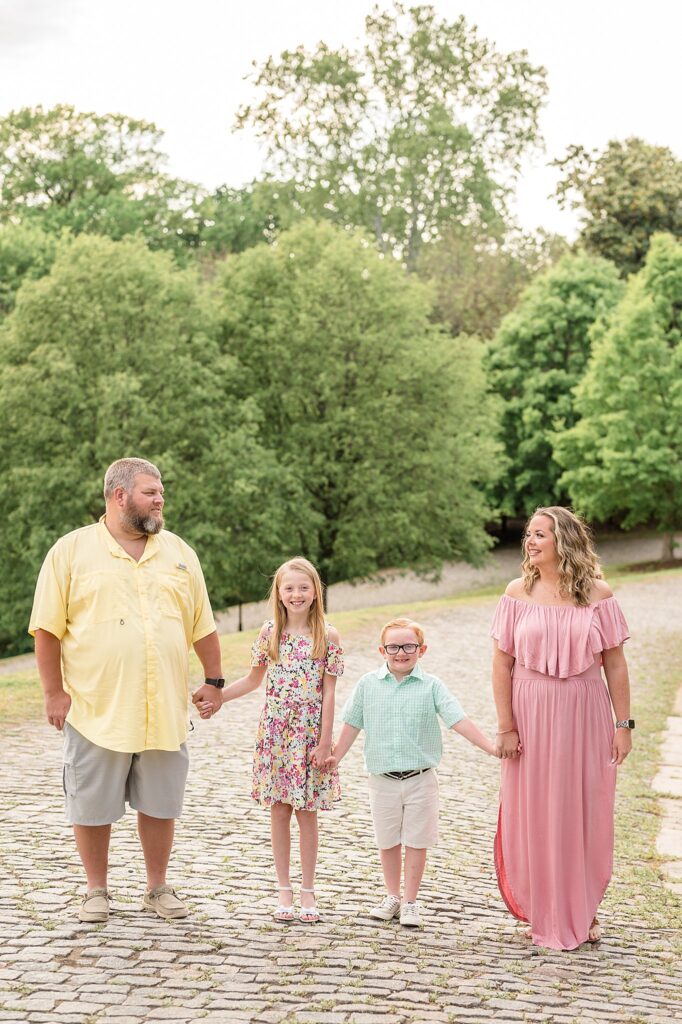 A family of four wear coordinating spring colors, light pink, yellow, mint, and floral during their Richmond family session at Libby Hill Park.