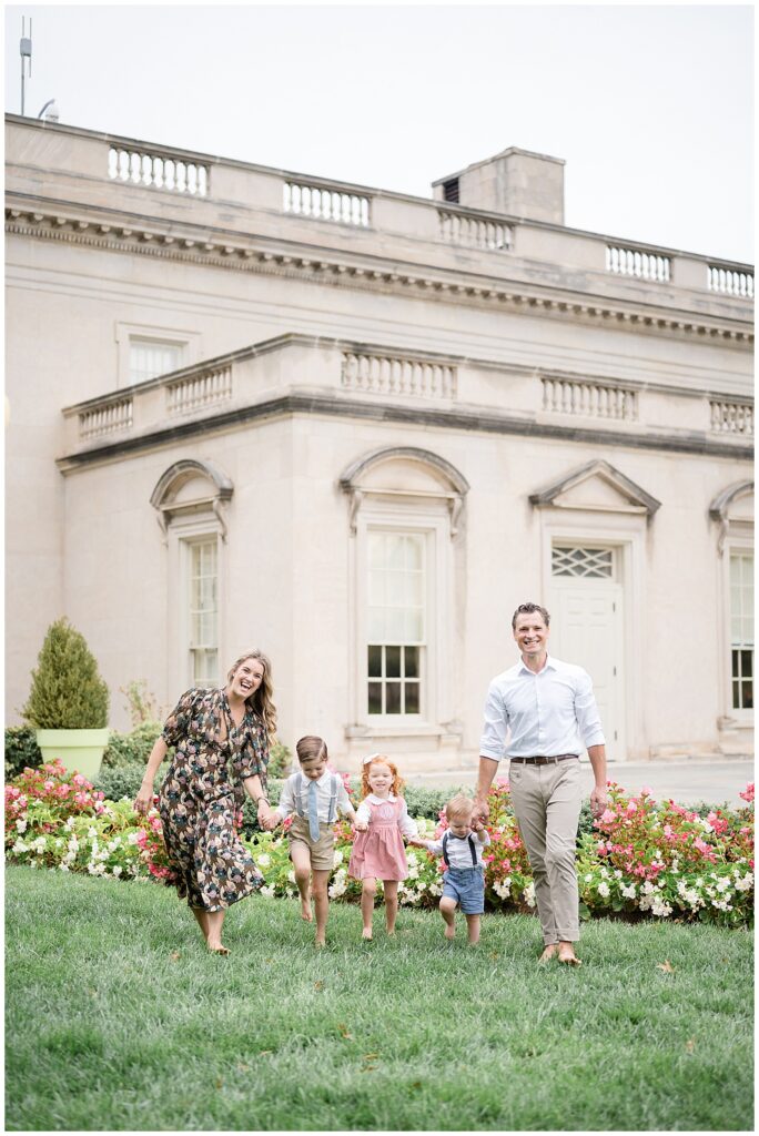 Mom and Dad are on the ends holding hands with their kids in the middle as they run towards the camera during their Richmond Mini Session.
