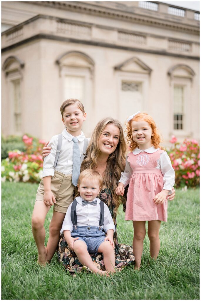 Wisp + Willow Photography Co. capture a picture with mom and her 3 young kids, 2 boys and a girl as they smile at the camera at the Virginia Museum of Fine Arts.