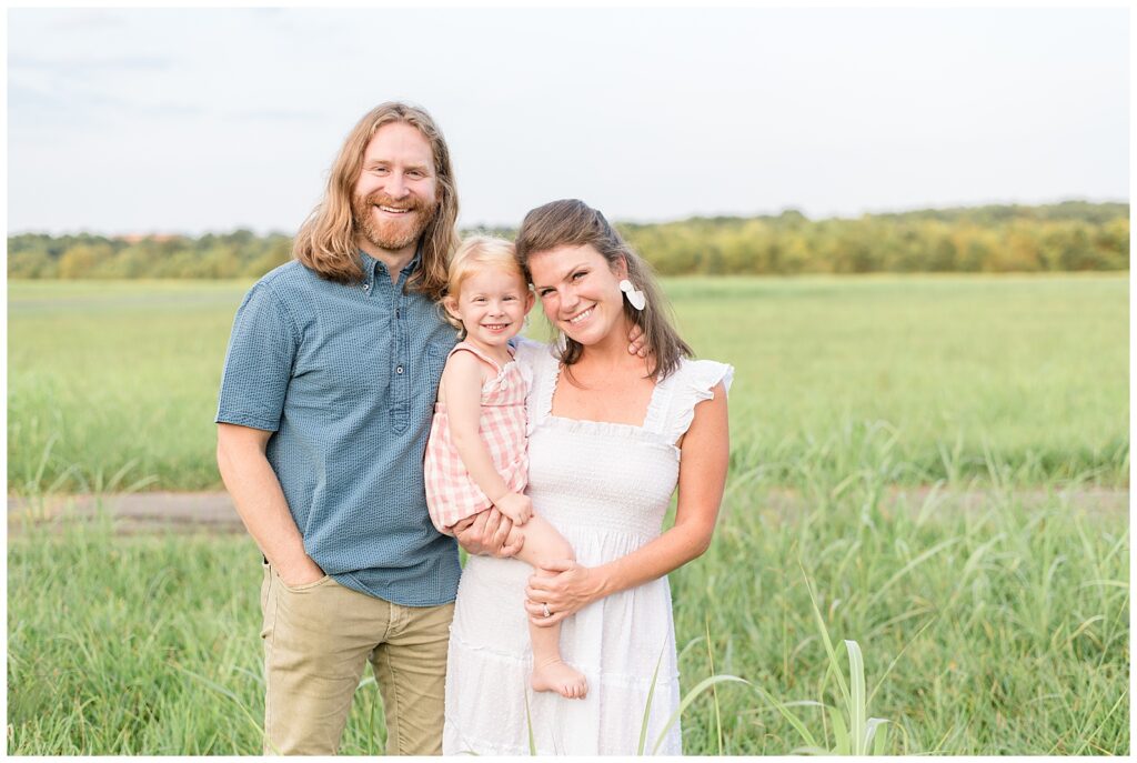 Nashville family session has mom wearing a beautiful white dress, the dad rocked a blue button-up shirt, and their little girl looked adorable in a white and pink plaid romper.