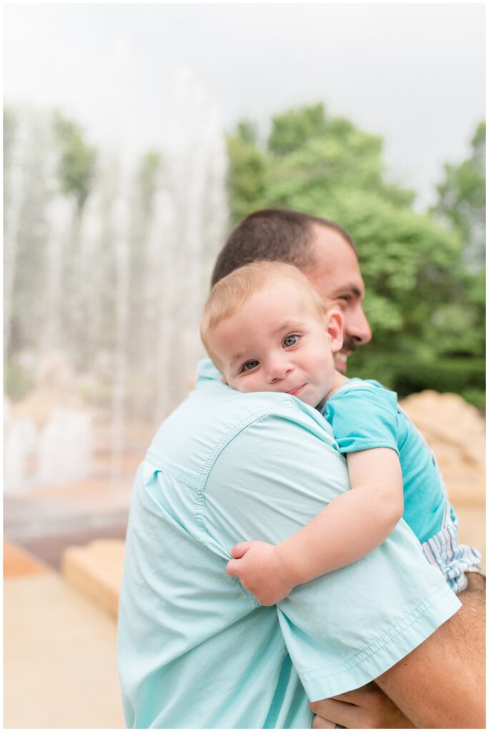 Dad holds son as he rests his head on his shoulder as he gets sleepy during the end of their family session at Coolidge Park in Chattanooga, TN.