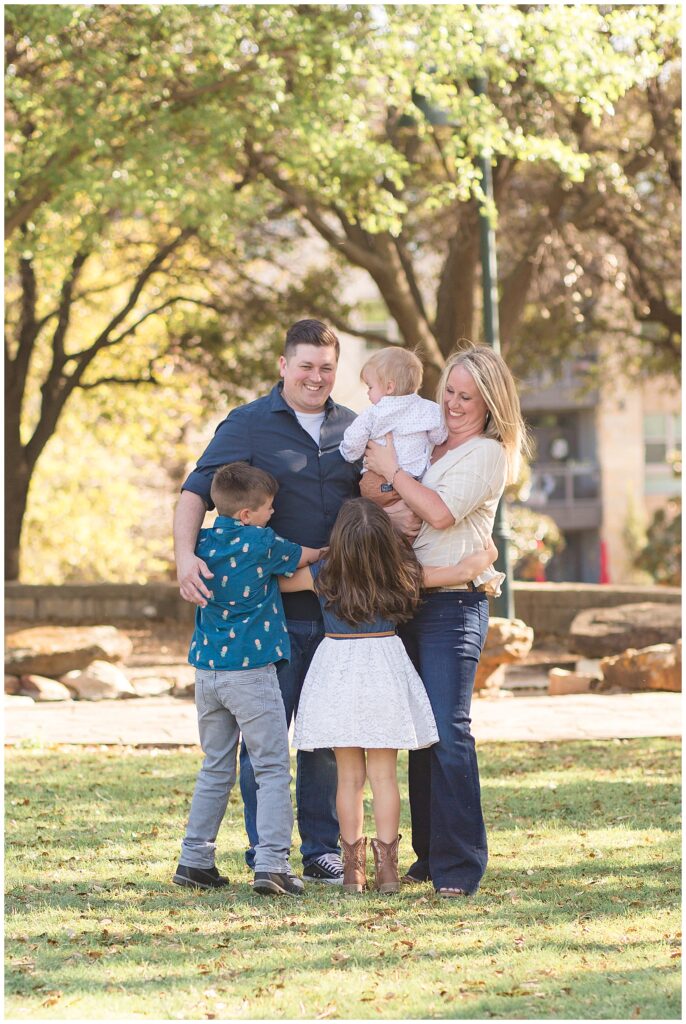 Family of 5 share a big family hug during their Frisco family session at Frisco Central Park with Wisp + Willow Photography Co.