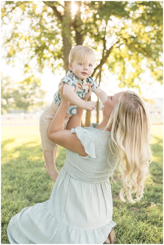 Mom who holds toddler son up in the air as he smiles at the camera of Franklin photographer, Wisp + Willow Photography Co. enjoy a moment during their Harlinsdale Farm portraits.  Click now to see more on the blog today!