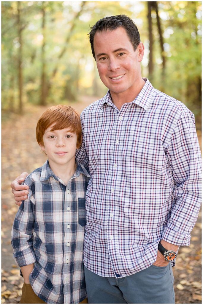 Father and son wear plaid, button down shirts as they smile at the camera of Wisp + Willow Photography, Co.