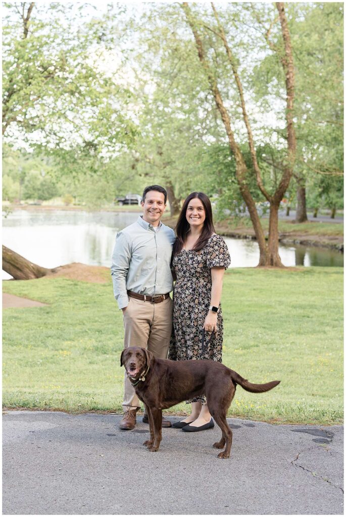 Couple stands in front of the Shelby Bottom Nature Preserve with their chocolate lab for new updated family pictures.