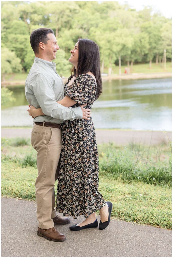 Couple stands in front of the nature preserve in Nashville, TN standing belly to belly and looking at each other and smiling.