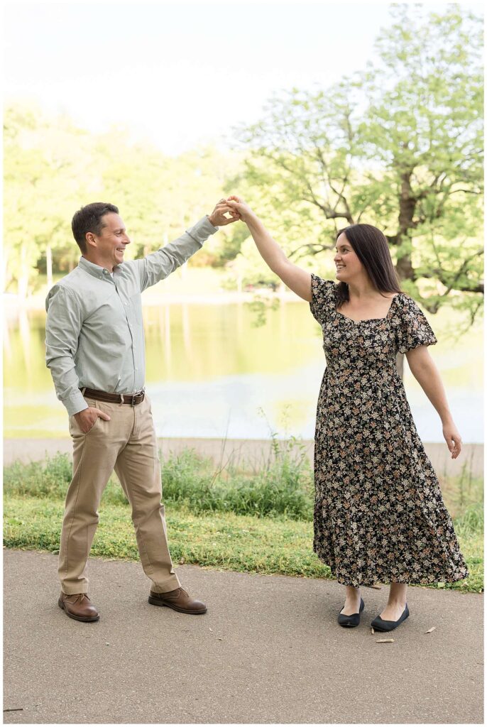 Couple dances in front of the lake on a pathway as husband twirls his wife while they keep their eyes on each other!  More from this couple on the blog today!