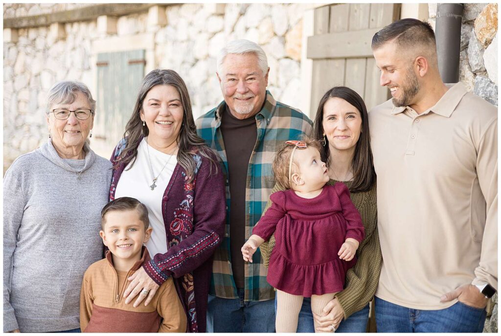 Extended family portraits of 5 adults and 2 children are taken at Adriatica Village in McKinney, TX by Wisp + Willow Photography Co.  They wear fall colors for their family portraits.  Click to see more on the blog today!