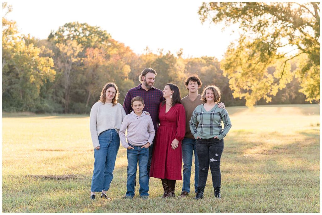 Chattanooga family session taken by Wisp + Willow Photography Co. show an image of 4 older children looking at the camera ranging from middle school to college aged and the parents in the middle looking at each other.