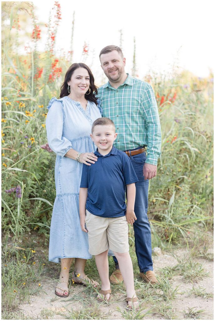 Family of 3 take family portraits at Erwin Park in Texas coordinating in blue and green colors in their outfits.
