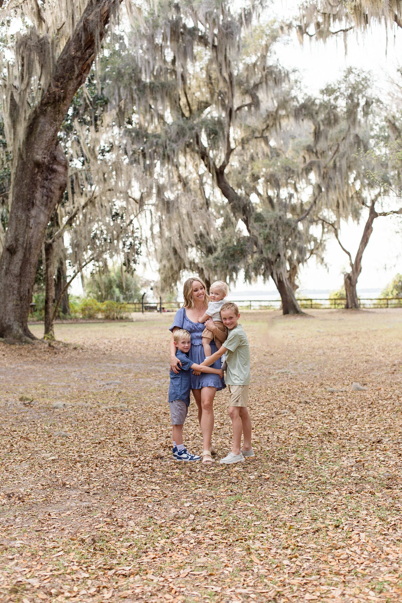 Mom in blue dress poses with 3 sons for Jacksonville family session at Alpine Groves Park with family photographer Wisp + Willow Photography Co. 