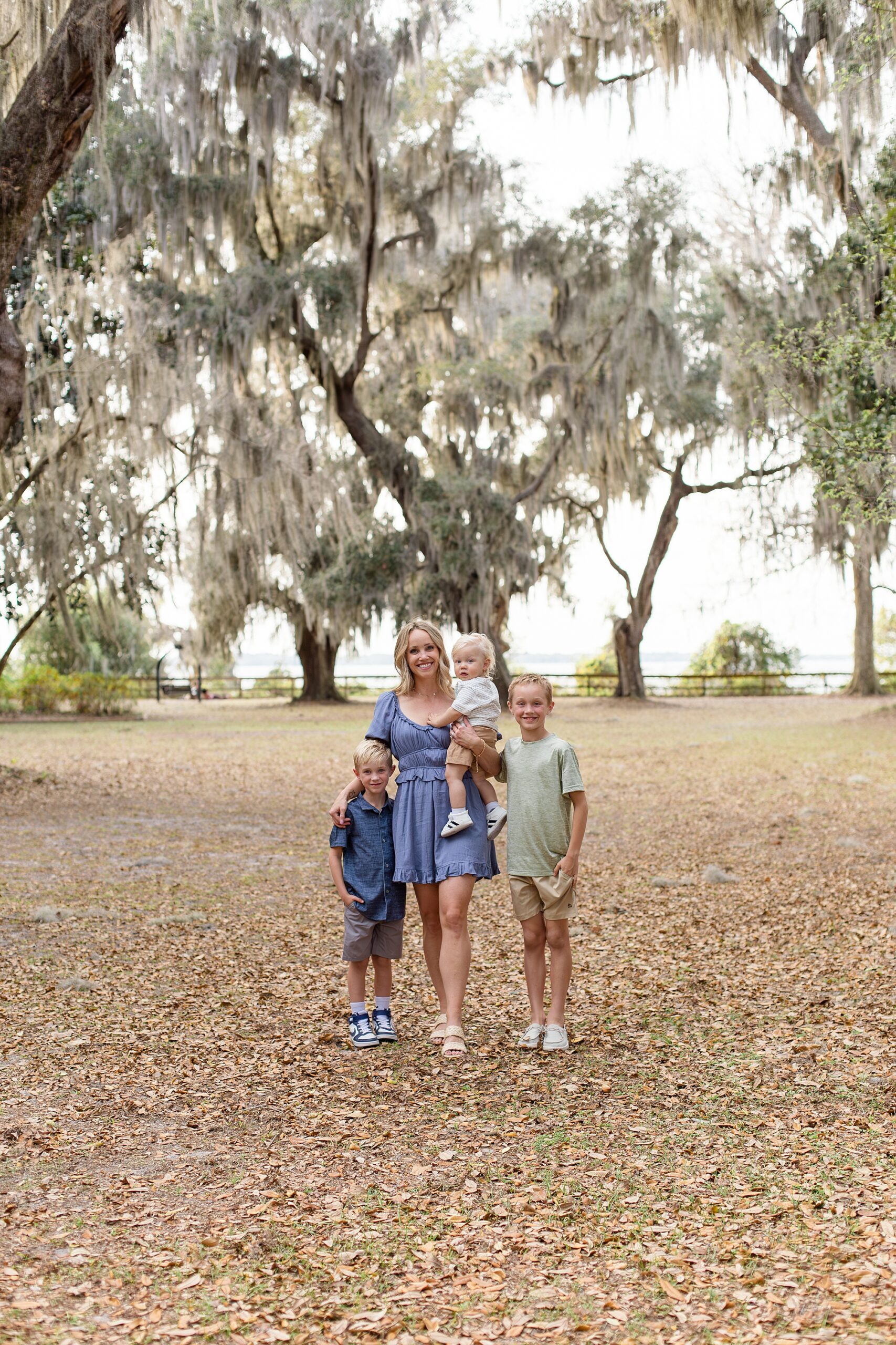Mom in blue dress poses with 3 sons for Jacksonville family session at Alpine Groves Park with family photographer Wisp + Willow Photography Co. 
