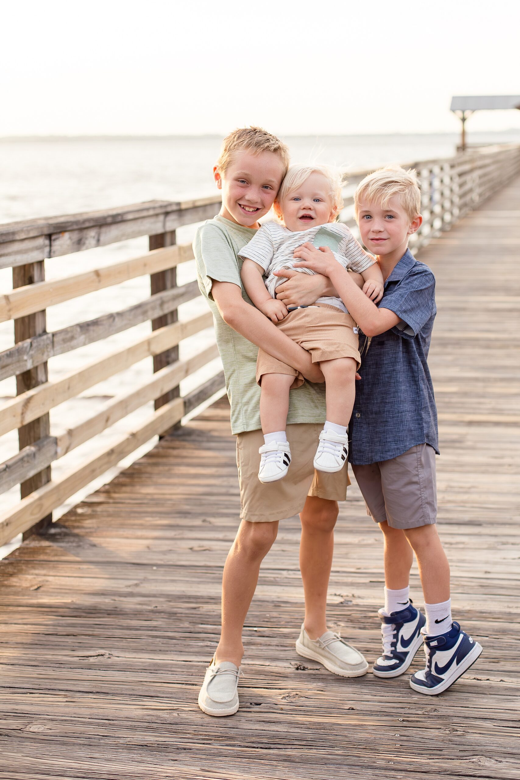 3 brothers pose together on pier in Jax, FL with associate photography team Wisp + Willow Photography Co. 