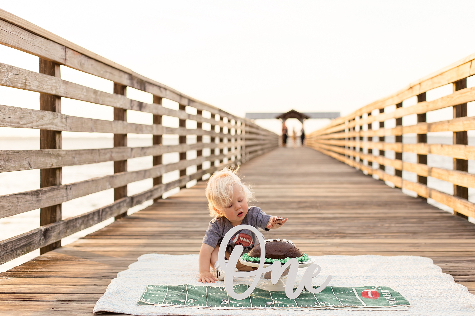 One year old celebrates birthday with smash cake on pier at Alpine Groves Park in Jacksonville, FL with Wisp + Willow Photography Co. 